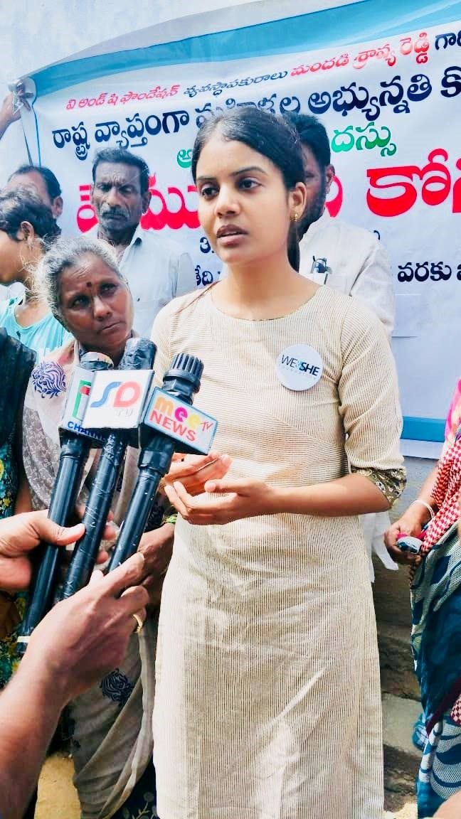 Shravya Mandadi speaking to reporters in front of a We for Her campaign banner