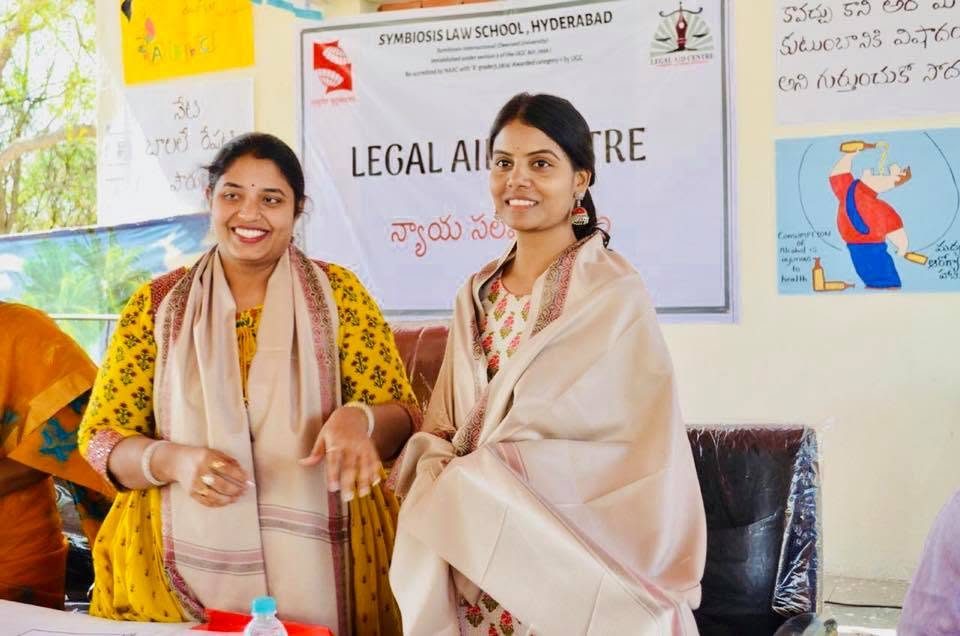 The founder and a woman leader smiling at a community meeting