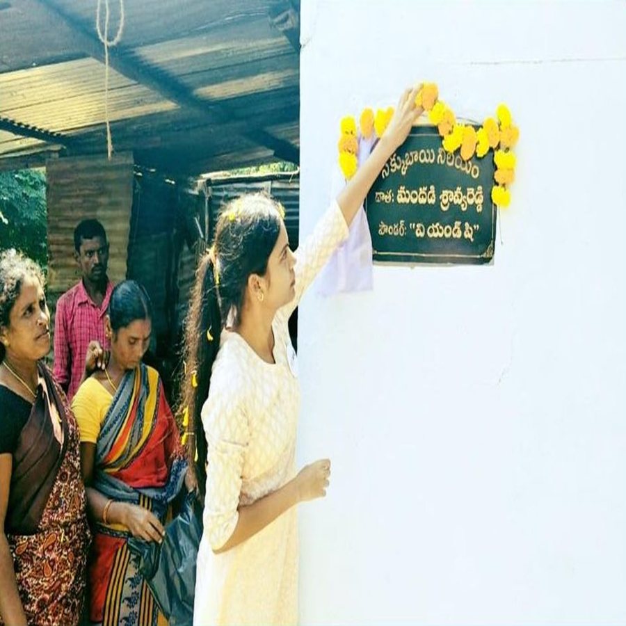 The founder unveiling a flower-garlanded name plaque on the wall of Sakkubhai’s new house as villagers watch